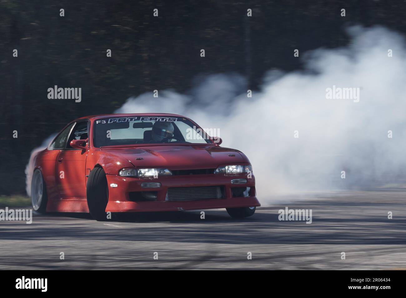 Red s14 mid drift with heavy throttle commitment creating tons of smoke. Stock Photo