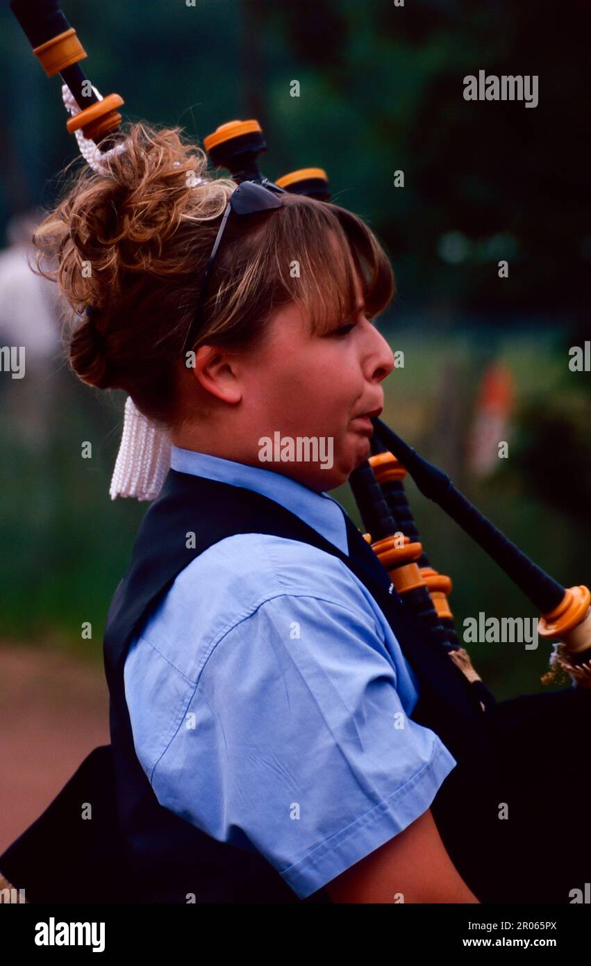 Girl piper playing bagpipes Stock Photo