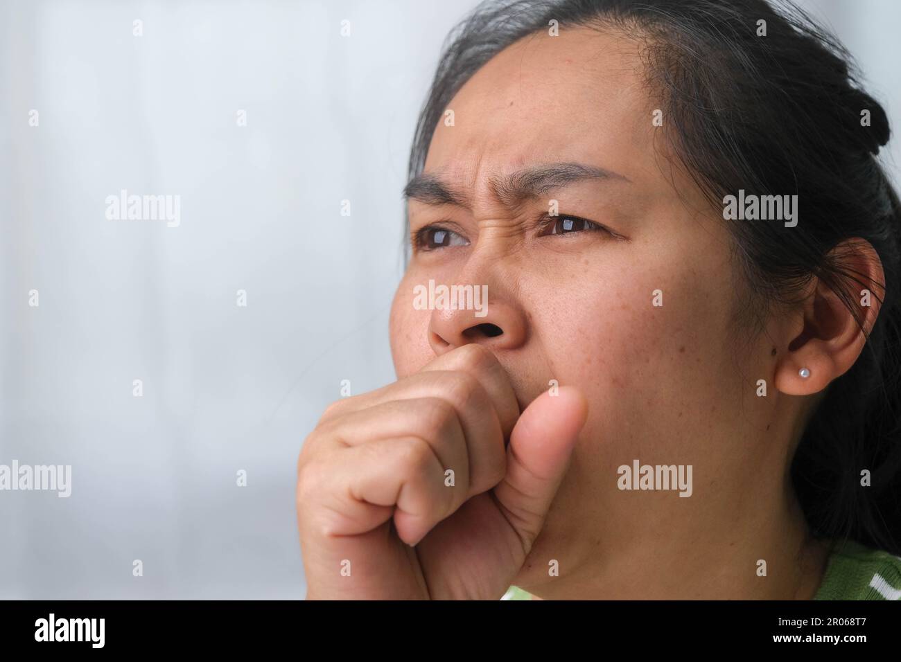 Illness young woman coughing at home. Sick woman coughing on her hands