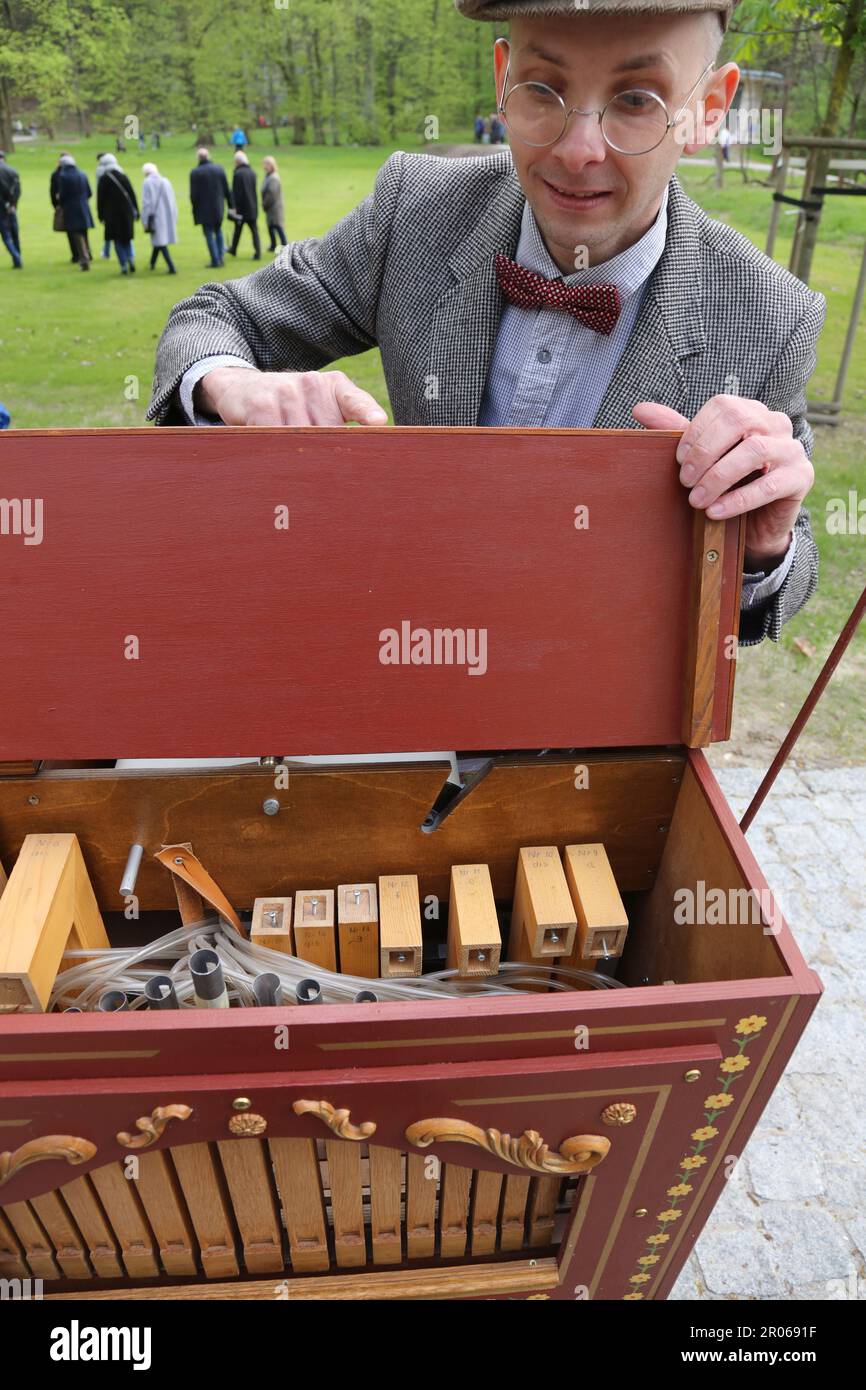 Cracow. Krakow. Poland.Male vintage costumed street entertainer busking in the park playing barrel organ. Inside of the instrument with organ pipes an Stock Photo