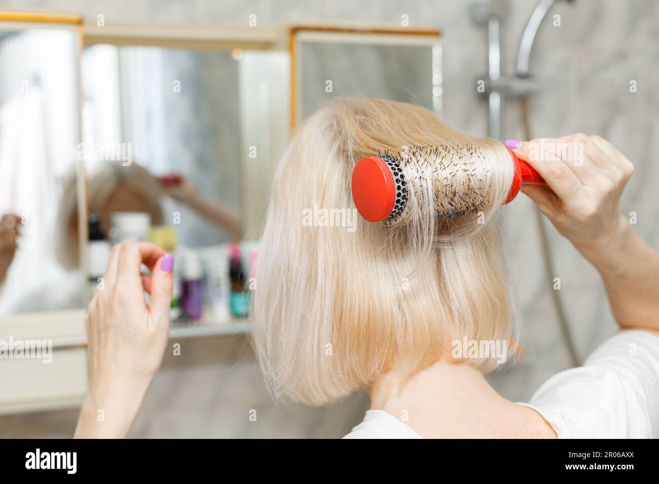 Woman doing hair in mirror hi-res stock photography and images - Alamy