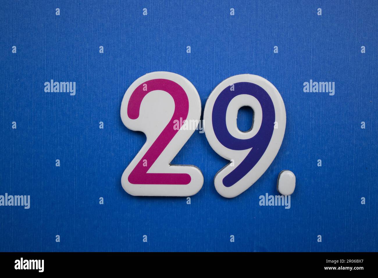 The number 29, placed on a blue background, photographed from above ...