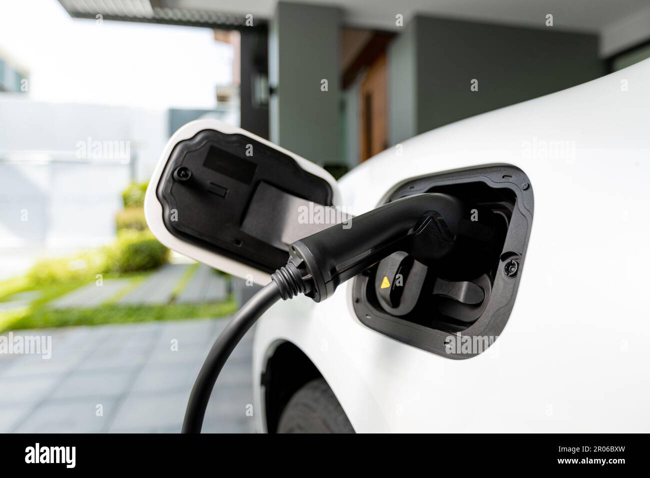 Closeup electric vehicle pluggedin with cable from charging point