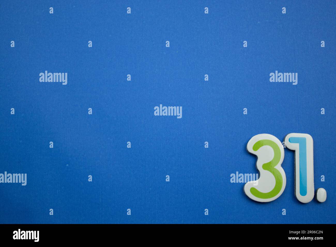 The number 31, placed on the edge of a blue background, photographed ...