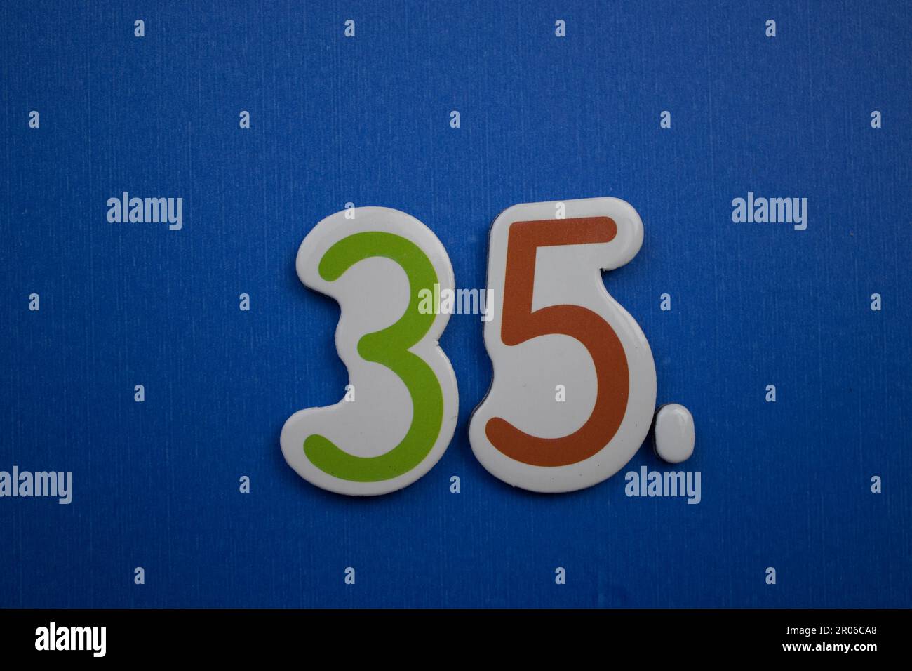 The number 35, placed on a blue background, photographed from above ...