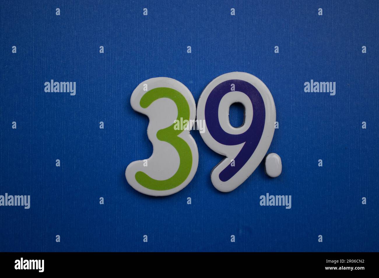 The number 39, placed on a blue background, photographed from above, colored green and dark blue. Stock Photo