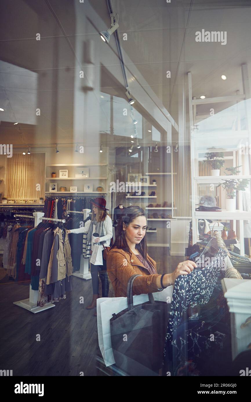 Im treating myself today. a young woman shopping at a clothing store. Stock Photo