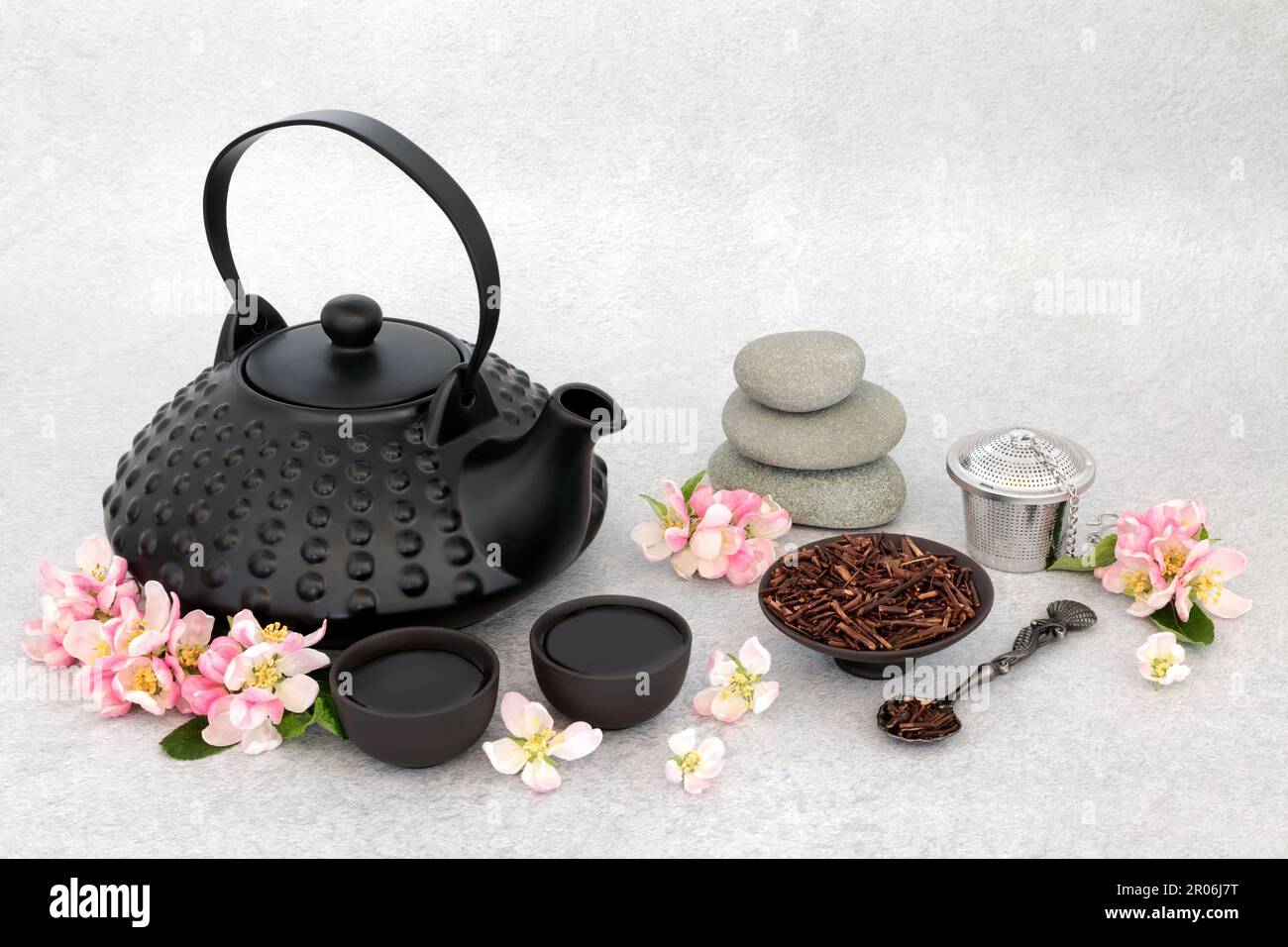 Japanese tea ceremony for contemplation and balance with pebble stack, ceramic tea set, apple