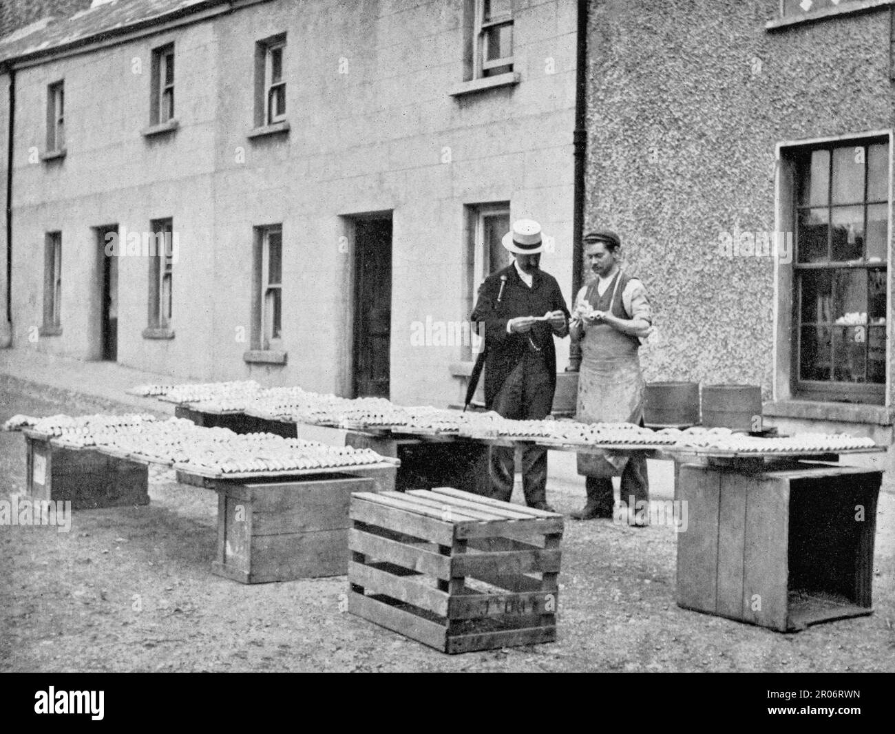 A late 19th century street scene in Drogheda, County Louth, Ireland in which a maker of clay pipes, called in Irish 'dudeen', chats to a potential customer. Stock Photo
