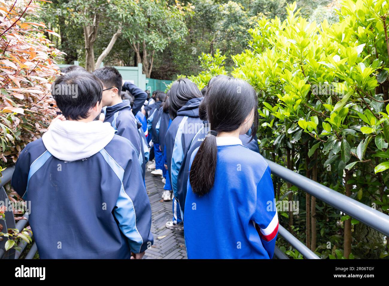 back view of happy young male and female high or middle school student in uniform marching or gathering for a major events in Shaoshan, Hunan, China Stock Photo