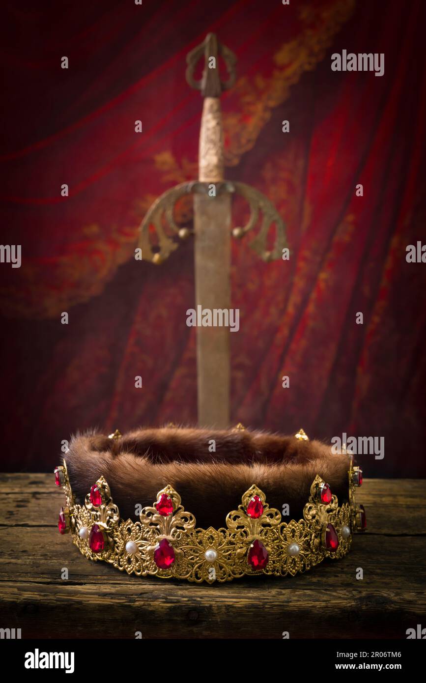 Golden king's crown and brass conquistador sword. This is a Spanish 19th century Toledo sword as used by medieval knights. Stock Photo