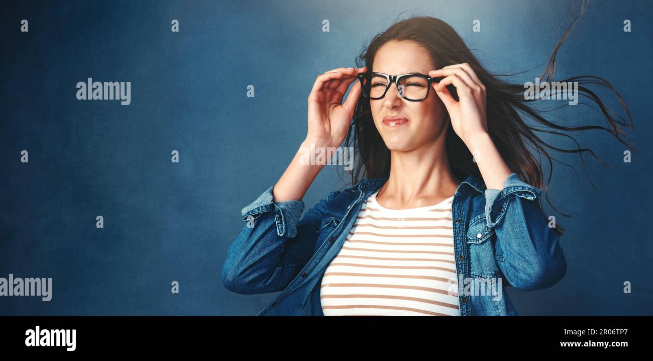 Now thats epic. Studio shot of a young woman with air being blown in her  face against a blue background Stock Photo - Alamy