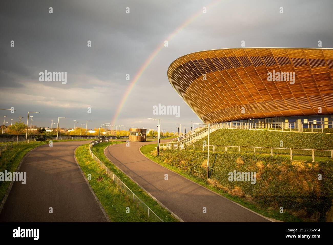 A rainbow can be seen over the velodrome roof (Pringle) in the Queen Elizabeth Olympic Park, Newham, London. Grey Clouds, England, UK. Stock Photo