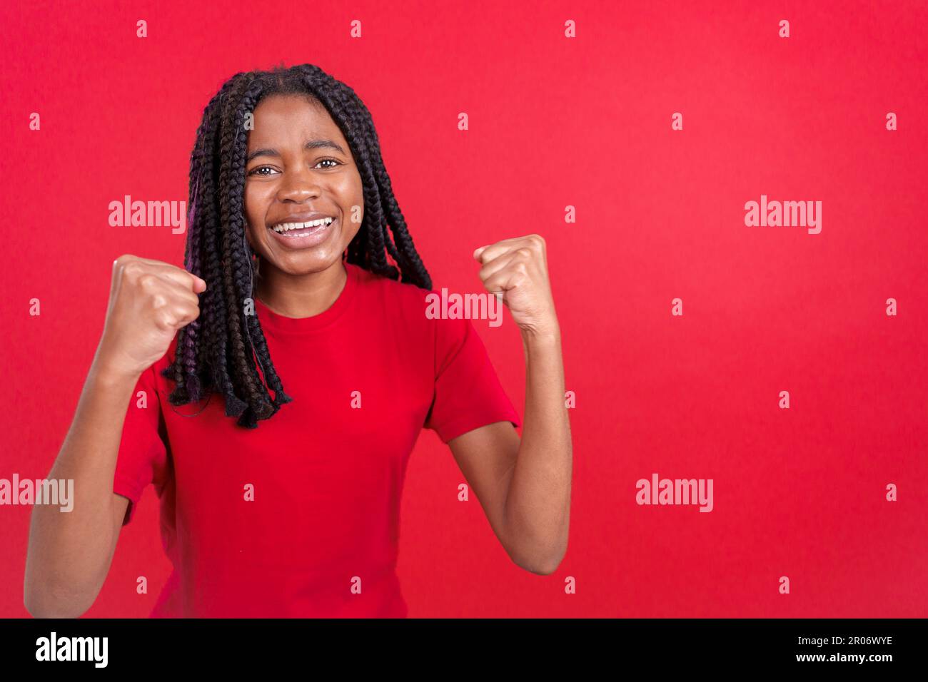 Happy african woman celebrating while raising arms Stock Photo - Alamy