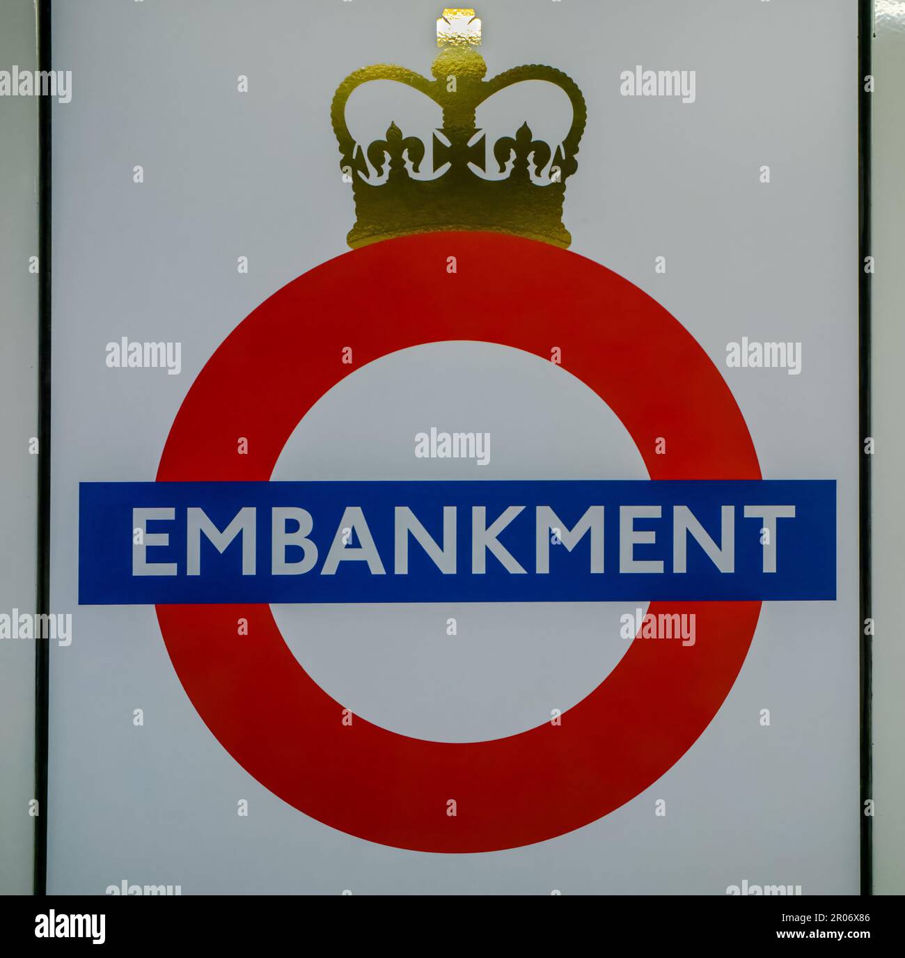 The iconic tube station sign of a red circle with a blue stripe, known to millions of commuters, is seen on a station sign at Embankment in the London Stock Photo