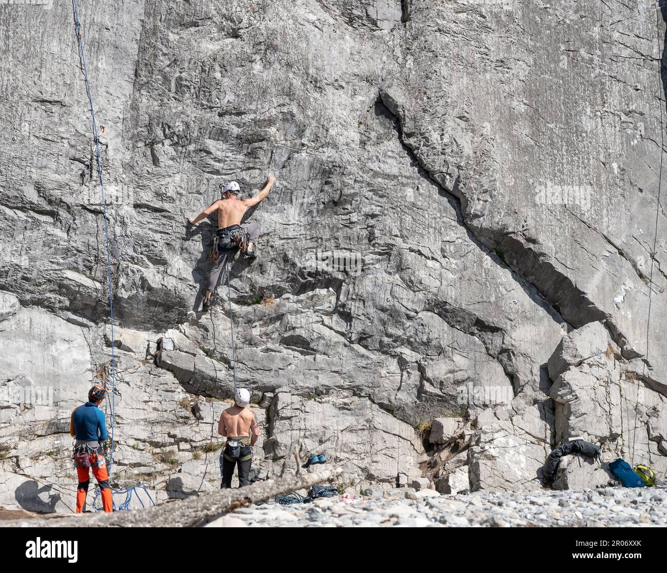 Banff National Park, Alberta, Canada – May 06, 2023: Three men engage in climbing a rock face Stock Photo