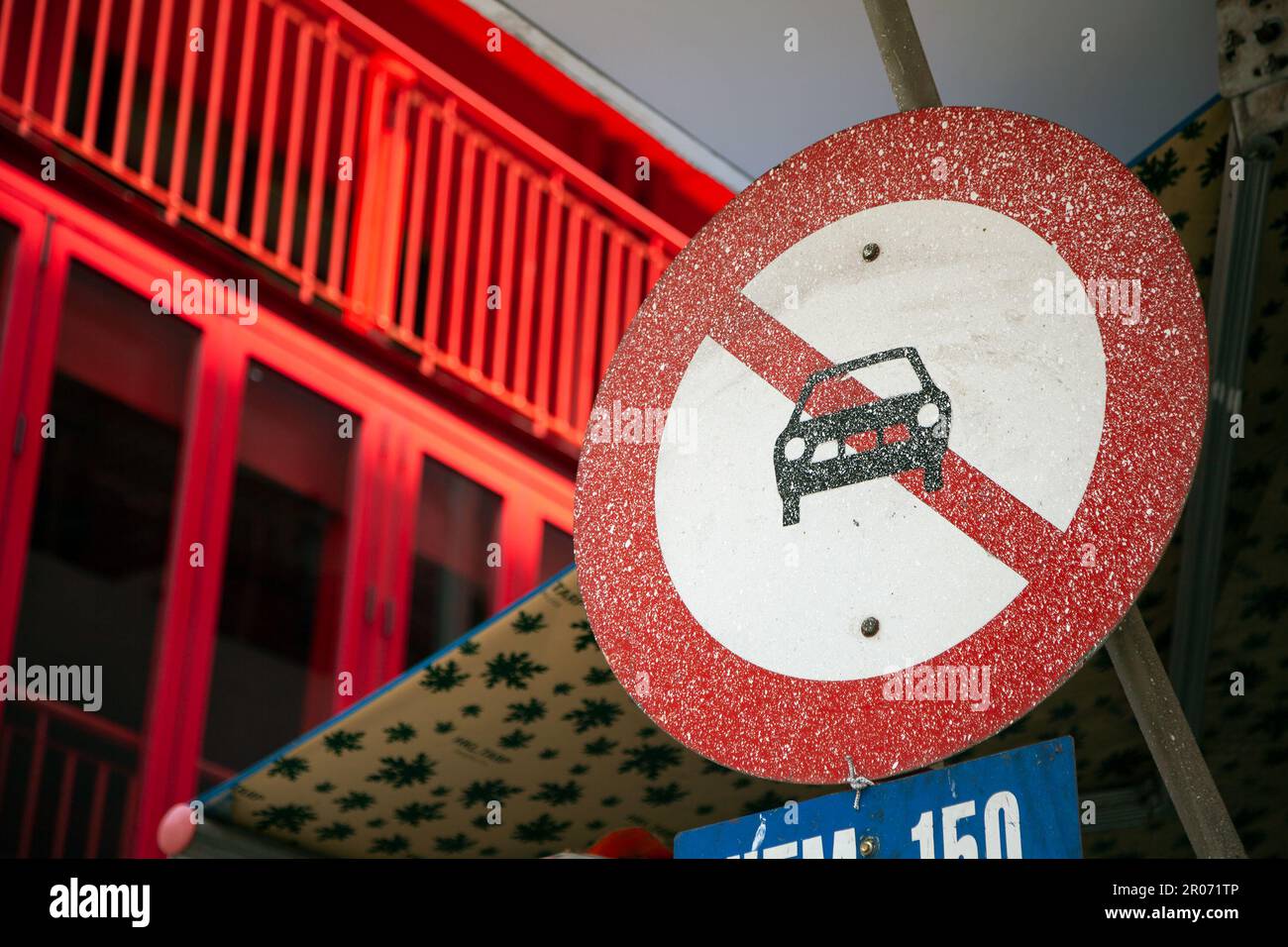 No cars allowed traffic sign on a city road. Red round sign with a vehicle crossed out, indicating that cars are prohibited Stock Photo