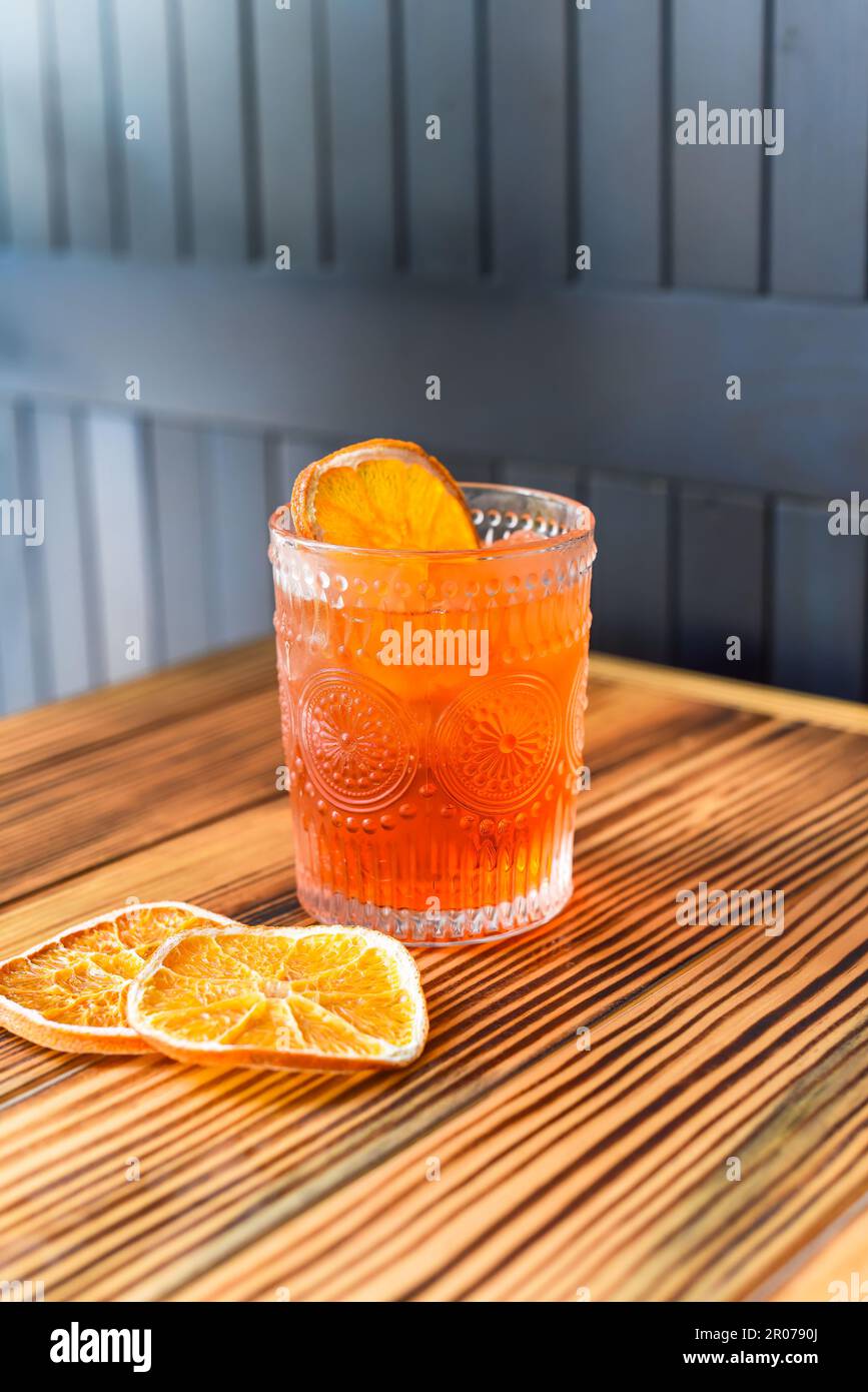Alcohol cocktail Aperol Spritz with slise of orange on wooden table against dark wall with copy space Stock Photo