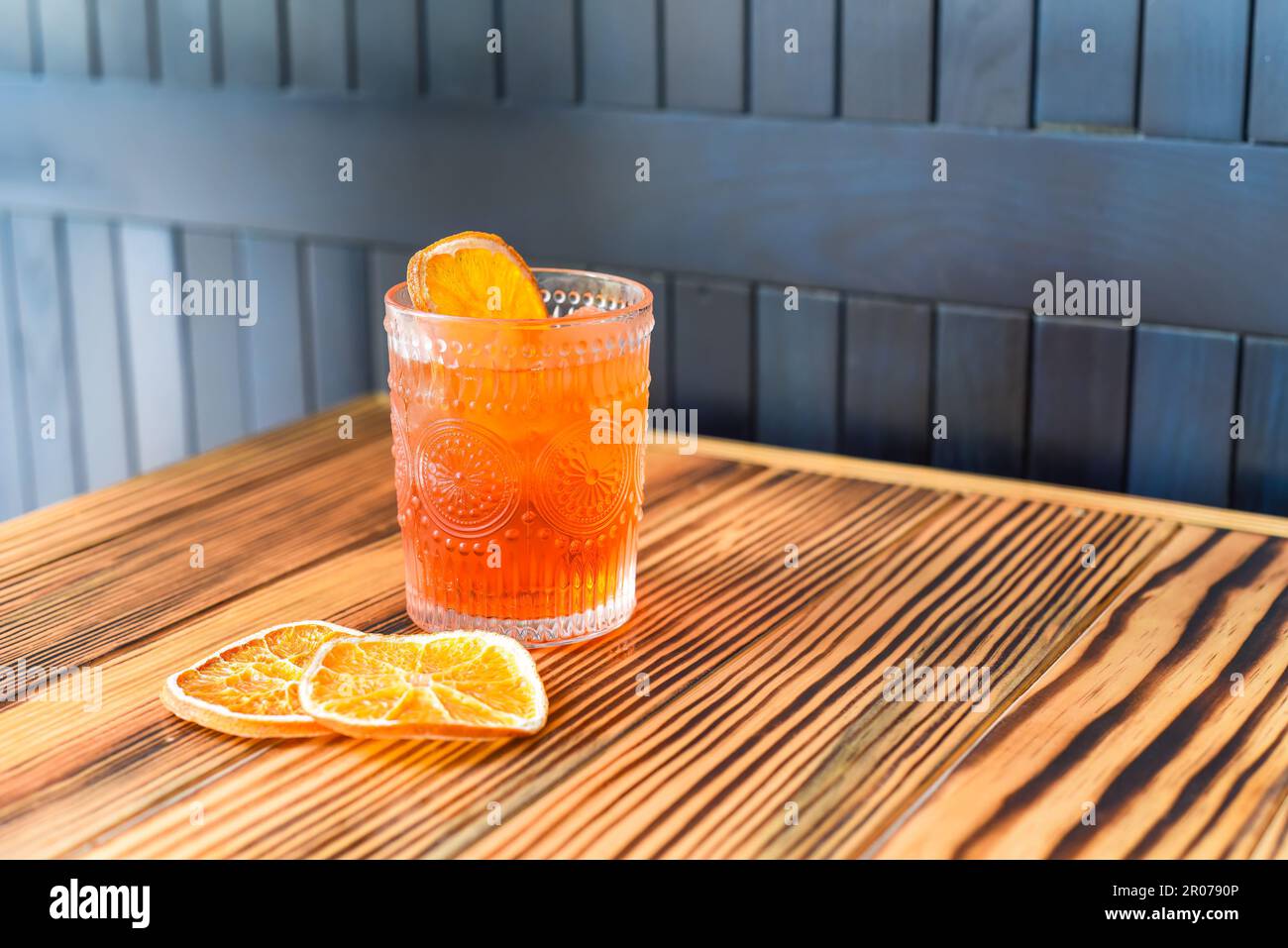 Alcohol cocktail Aperol Spritz with slise of orange on wooden table against dark wall with copy space Stock Photo