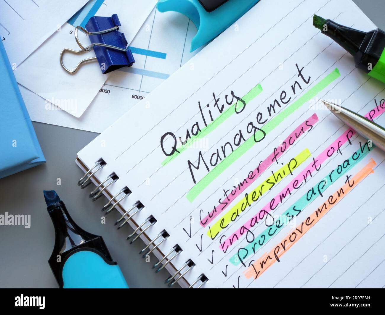 Open notebook with marks about Quality management. Stock Photo