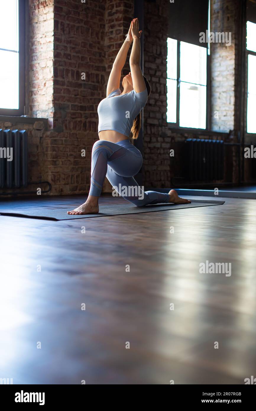 Anjaneyasana. Balance, mental health and slowlife concept. Yoga and meditation as a digital detox. Vertical photo. Stock Photo