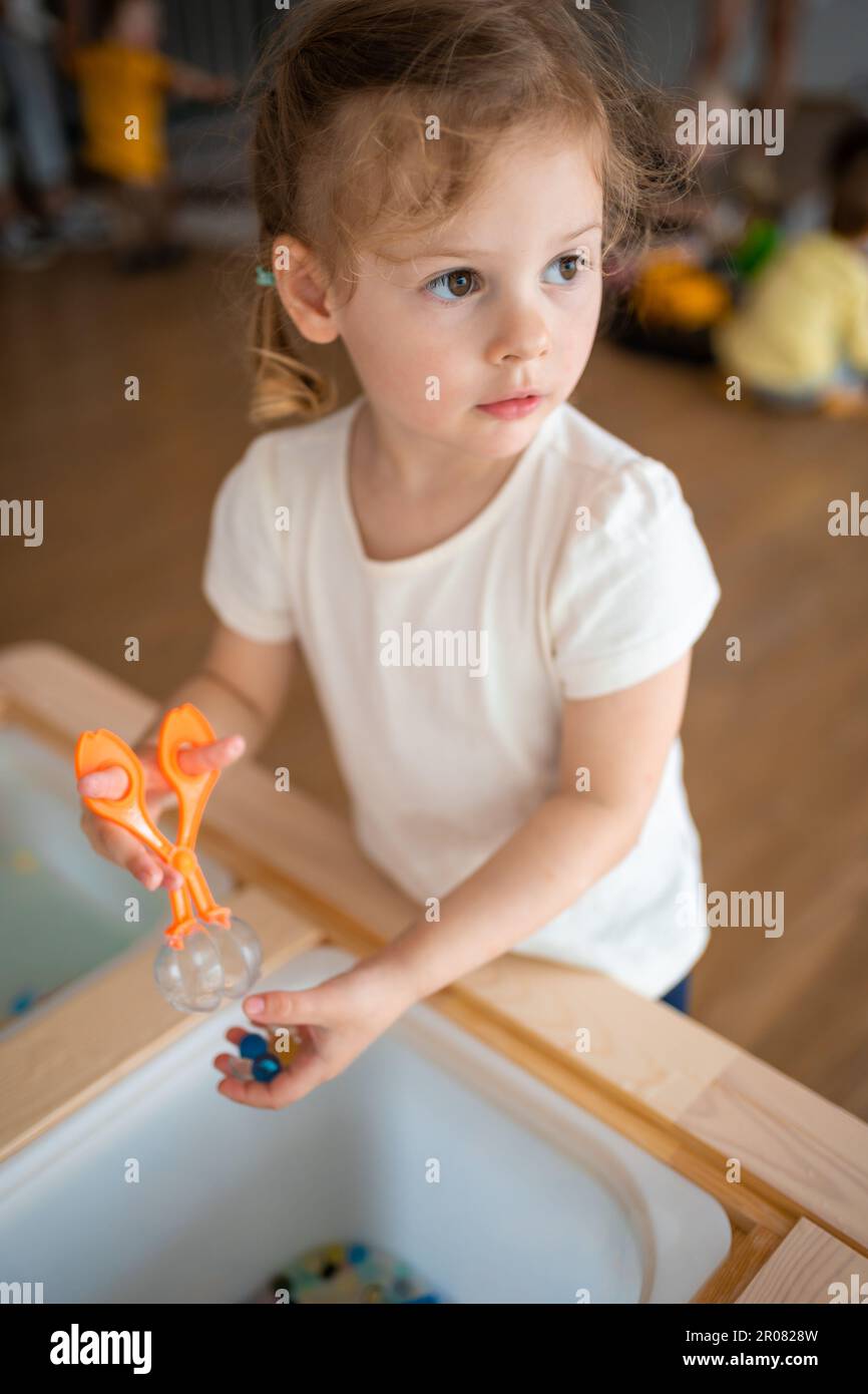 Little girl playing with sensory water beads, hydrogel balls. Sensory