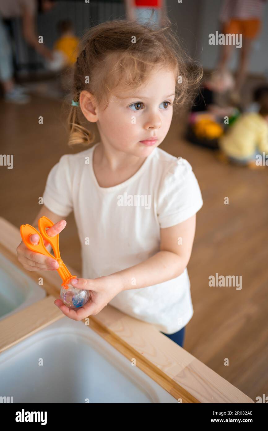 Little girl playing with sensory water beads, hydrogel balls. Sensory