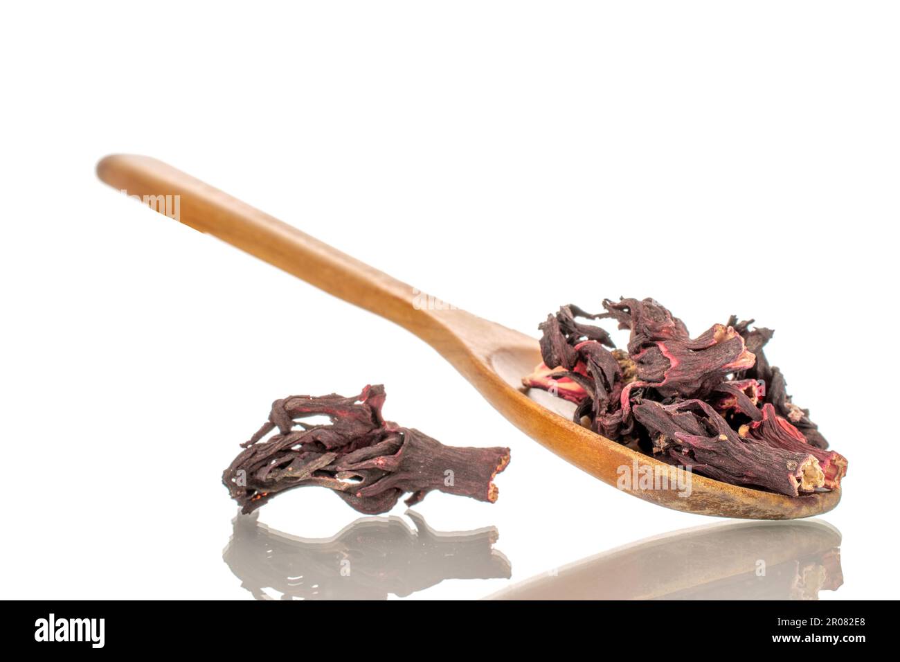 Karkade tea in wooden spoon, macro, isolated on white background. Stock Photo