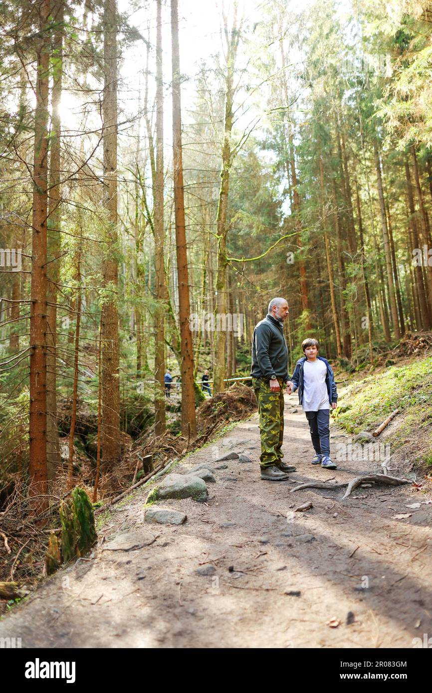 Father and son hiking in forest. Looking at map Stock Photo - Alamy