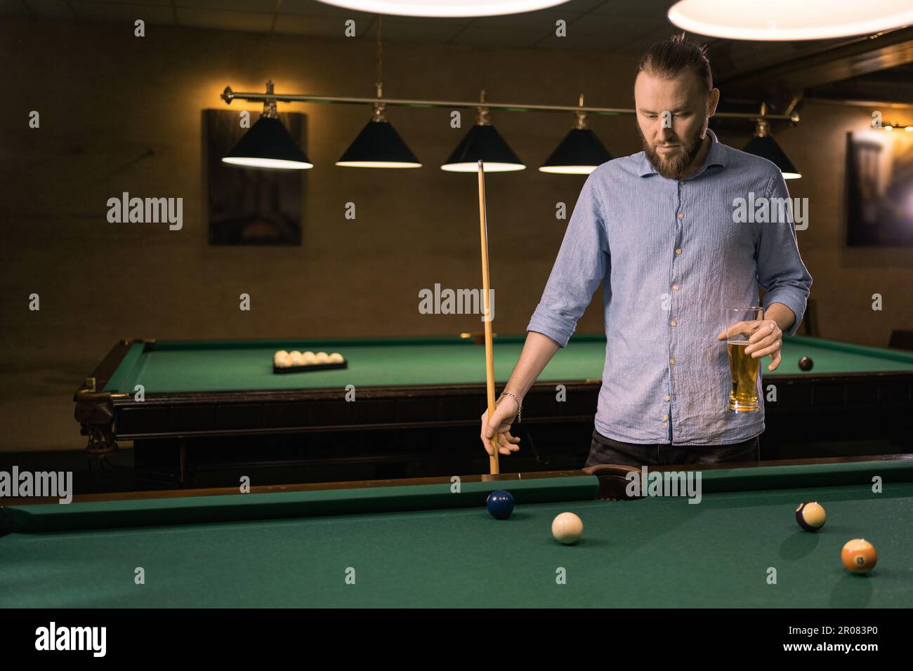 A Slender Man In A Shirt Puts Billiard Balls Into A High