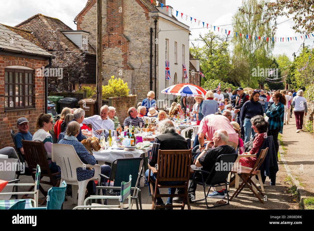 Brightwell-cum-Sotwell, Oxfordshire, UK. 7th May, 2023.  Villagers packed a closed section Brightwell Street for their Street Party celebration of the coronation of HRH King Charles. Tables and revellers occupied an estimated 200M of road. Live music would later entertain late into the evening. Credit: Stephen Bell/Alamy Live News Stock Photo