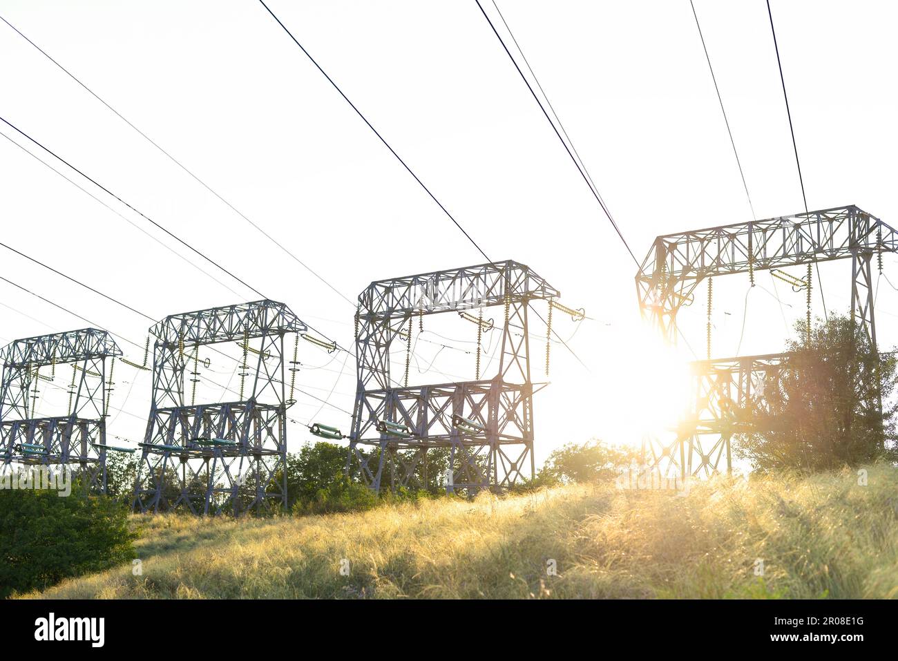 High-voltage power lines at sunset. High voltage electric transmission ...
