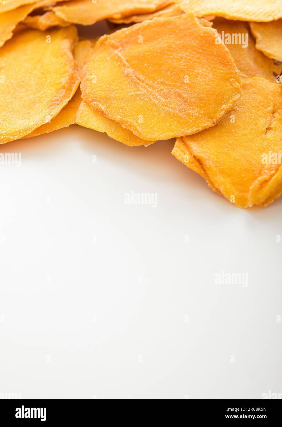 Dried large sweet mango slices on white background. Stock Photo