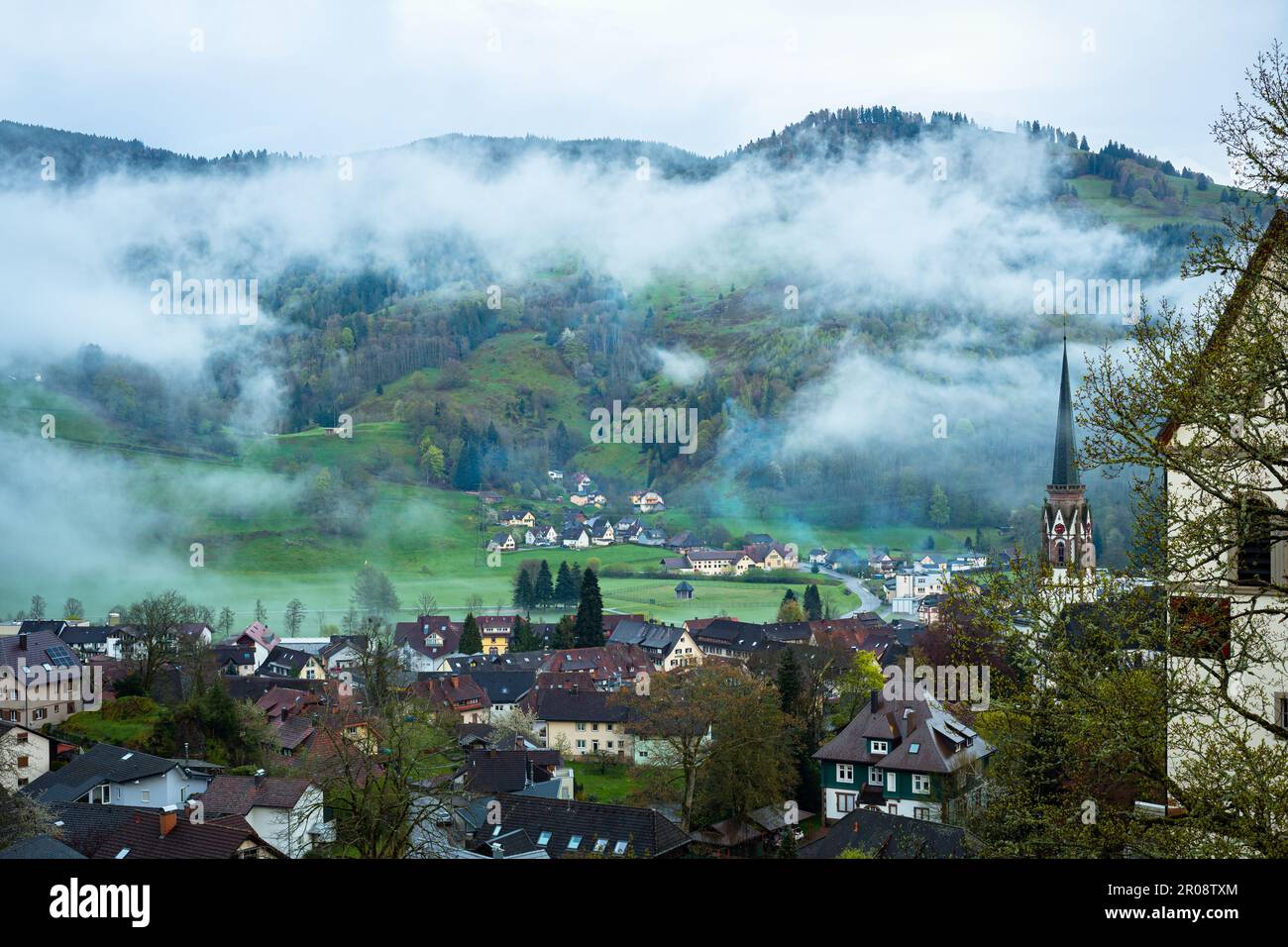 Clouds over the valley and village of Schönau im Schwarzwald in Black Forest area, Germany in the evening Stock Photo
