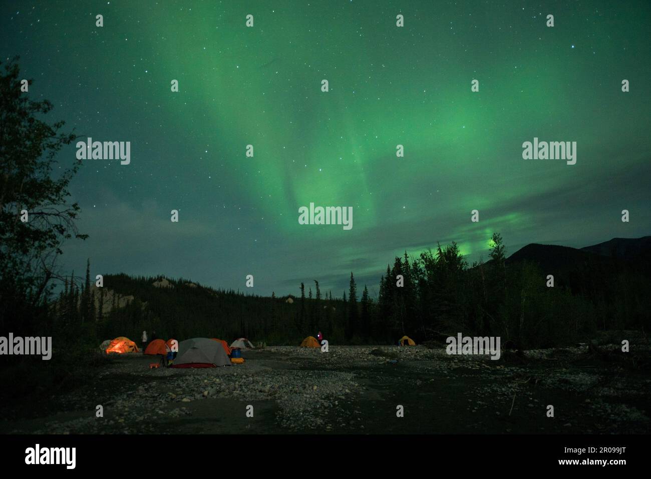 Northern Lights over camping tents, on a dry river bed in Nahanni