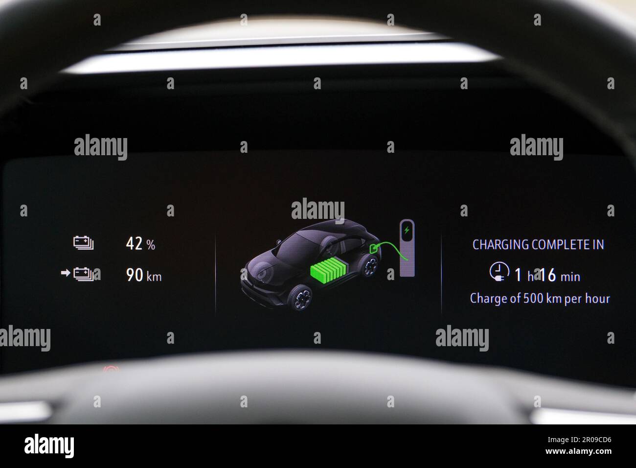 Close up electric car charger screen display with isolated steering wheel inside car. Selective focus of screen dispaly. Stock Photo