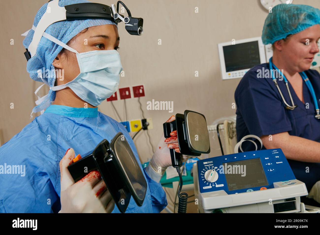 Its a matter of life and death. a surgeon using a defibrillator on a patient during surgery