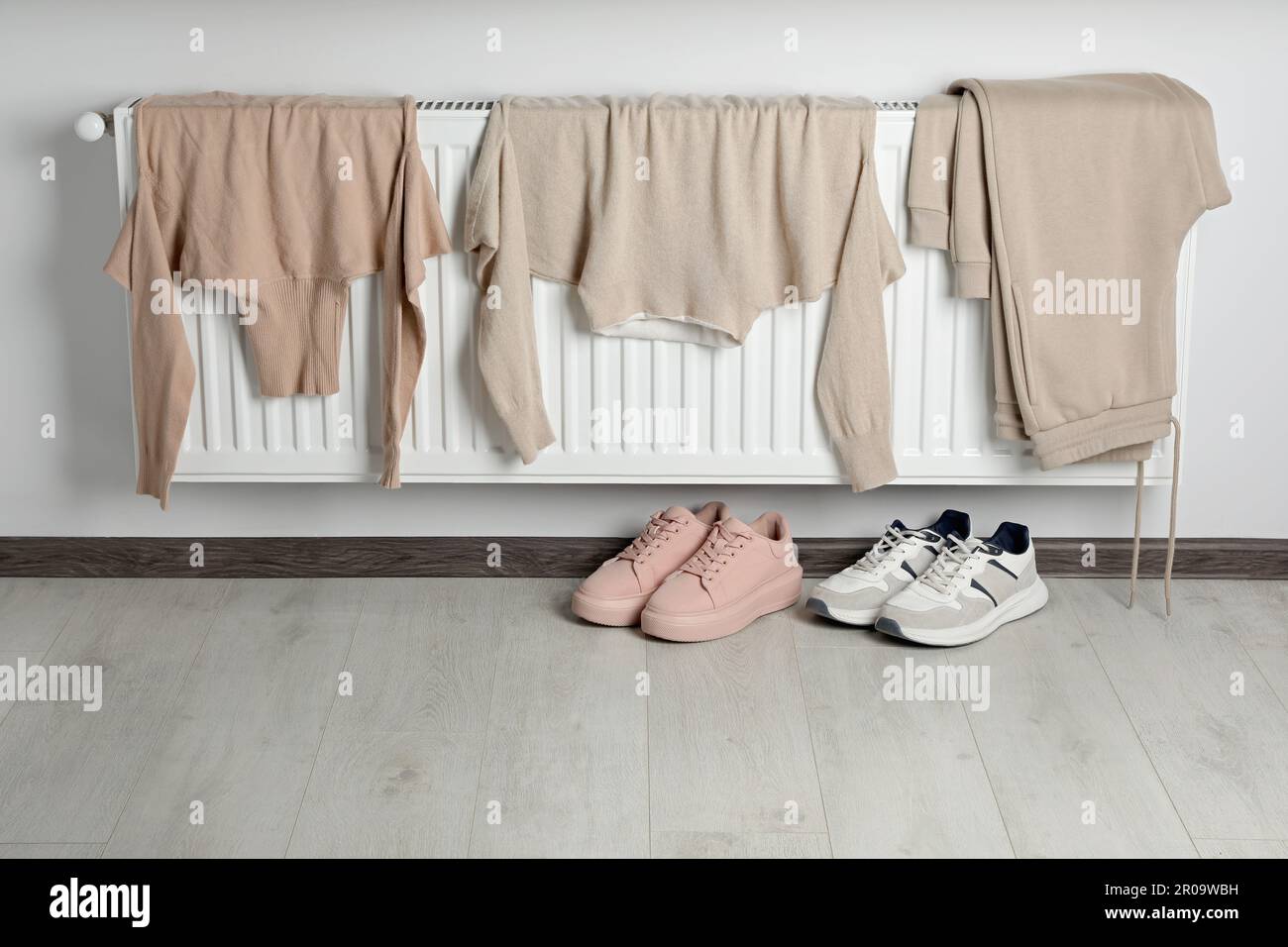 Heating radiator with clothes and shoes in room Stock Photo Alamy