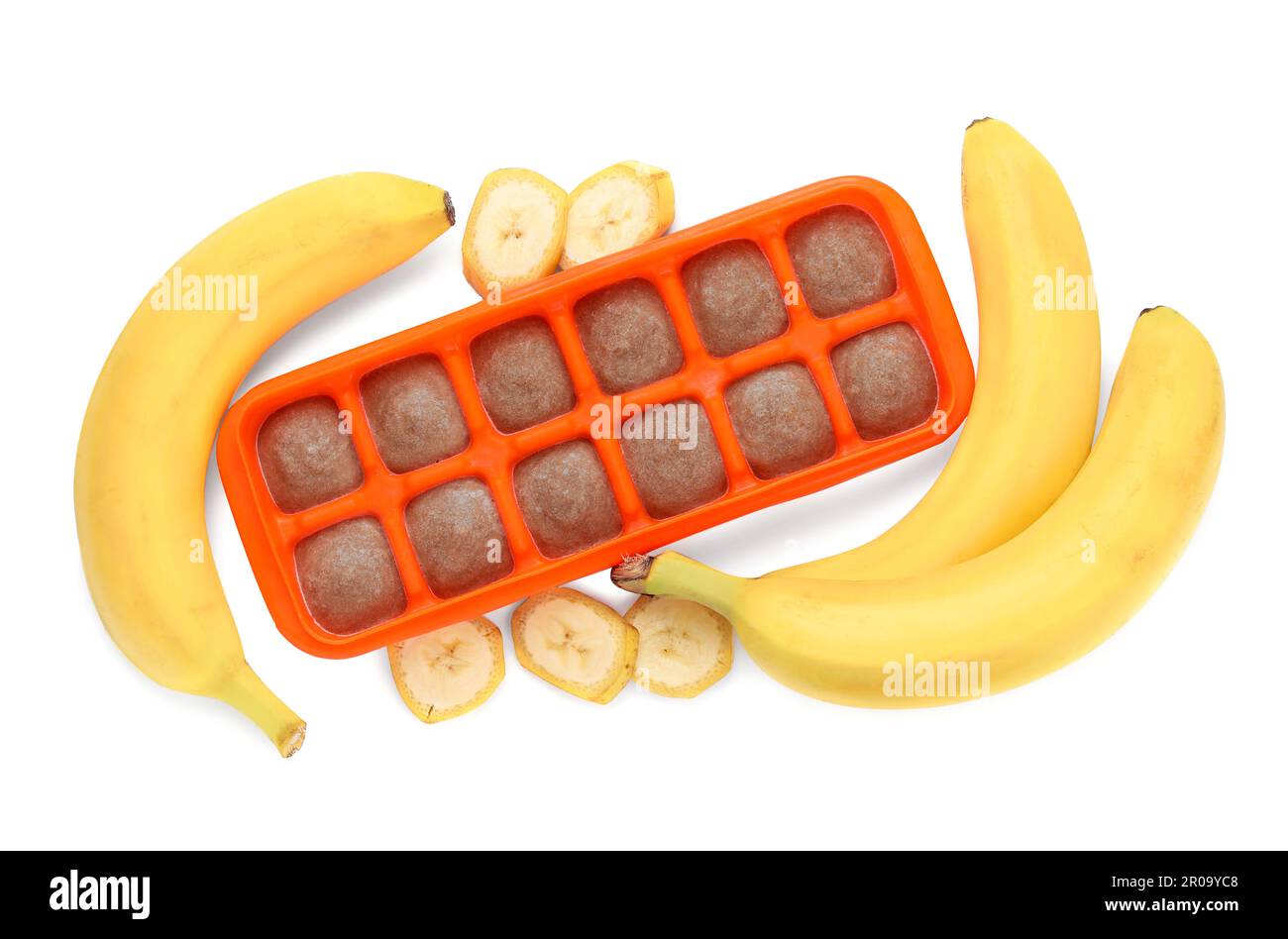 Banana puree in ice cube tray and ingredients on white background, top