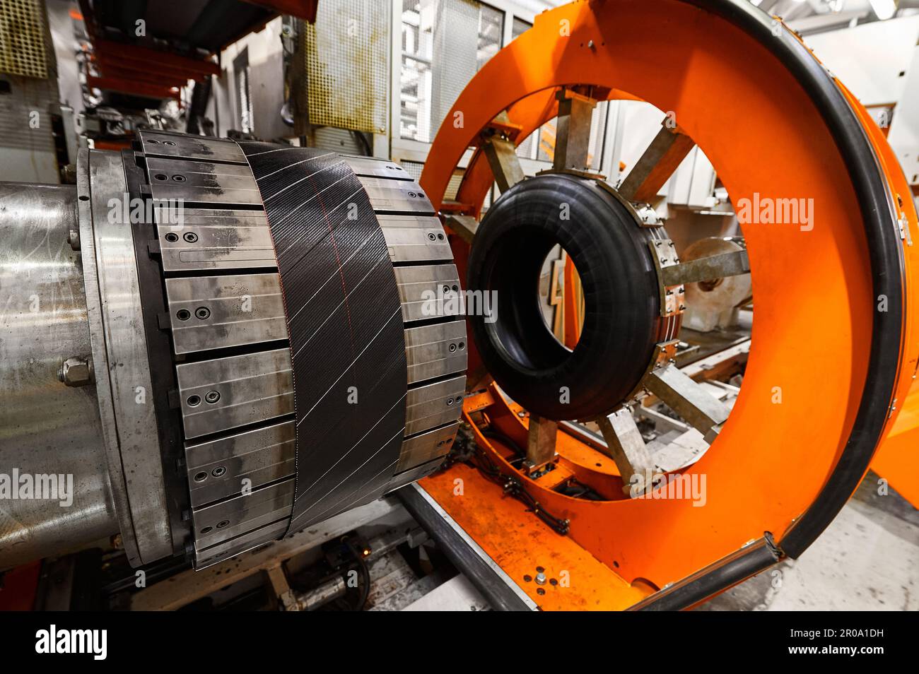 Rolling drum with rubber layers to form car tire at plant Stock Photo