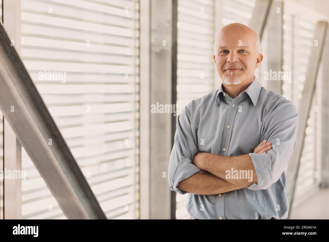 Old man in modern place smiles and thinks. He could at any time take charge of his life and change everything, because he fears nothing. he is ready f Stock Photo