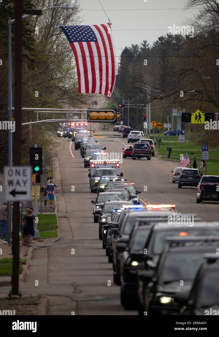 A procession of dozens of law enforcement vehicles follow the vehicle