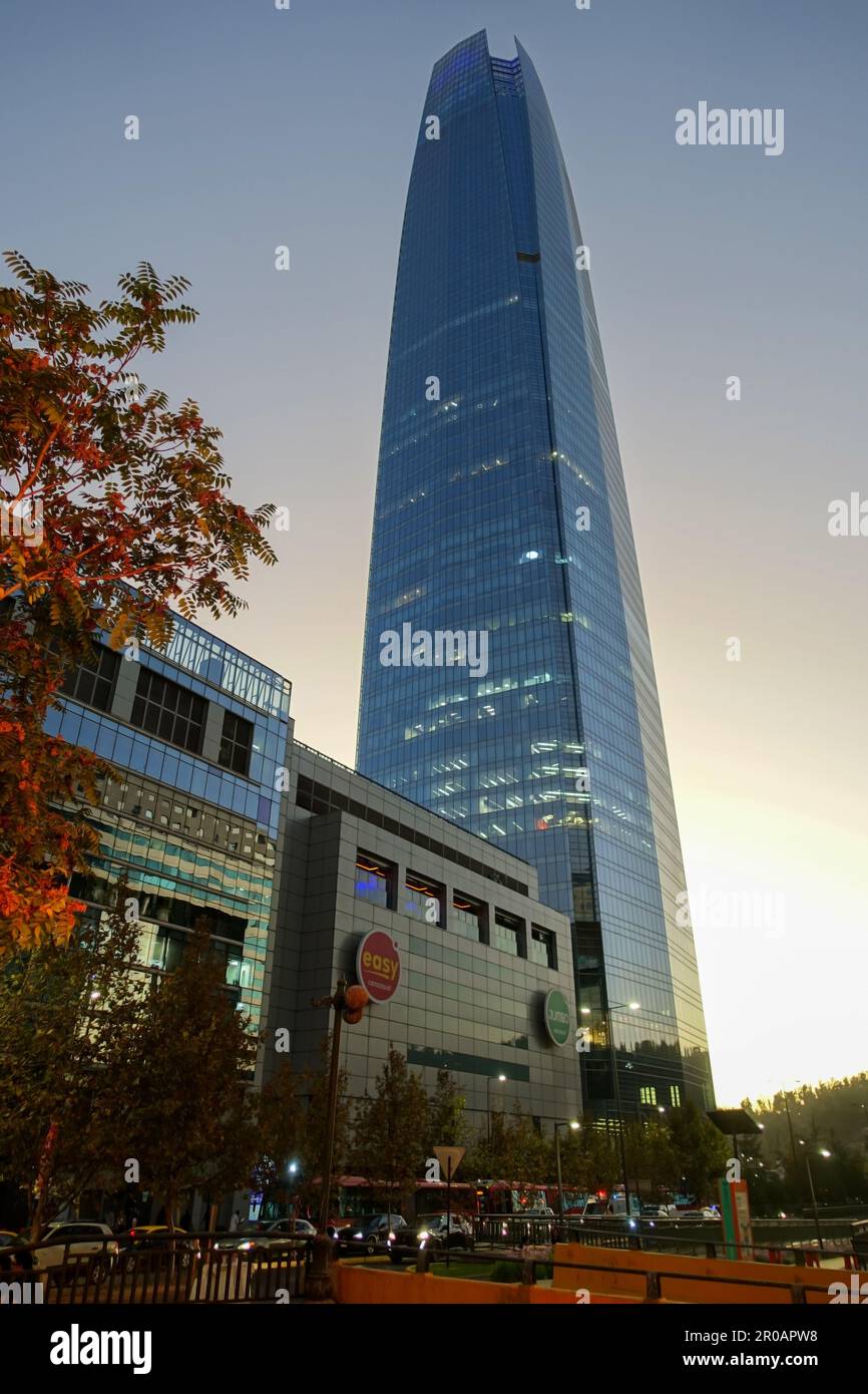 Santiago, Chile Street scene at Dusk in downtown district.  Vertical Portrait of Famous Costanera Skyrise Tower, Tallest Building in South America Stock Photo