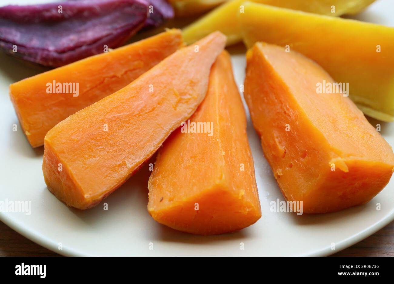 Plate of three different color steamed sweet potatoes, a good source of healthy carbs Stock Photo