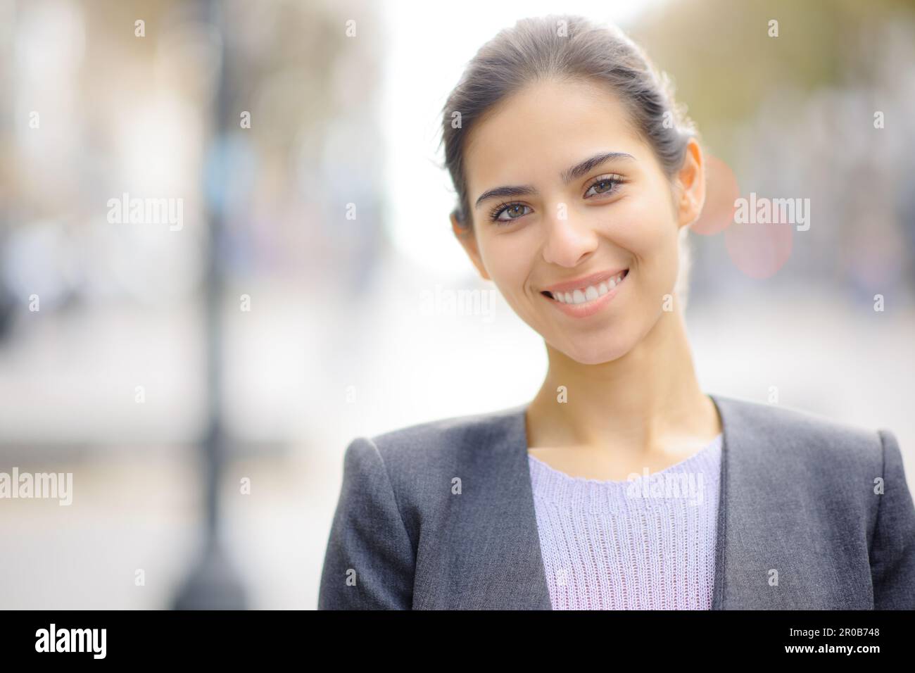 Front view portrait of a happy young executive looking at camera in the street Stock Photo