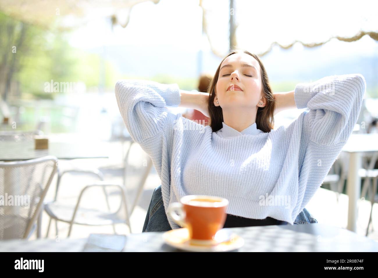 Relaxed woman with hands on head sitting in a coffee shop terrace Stock Photo