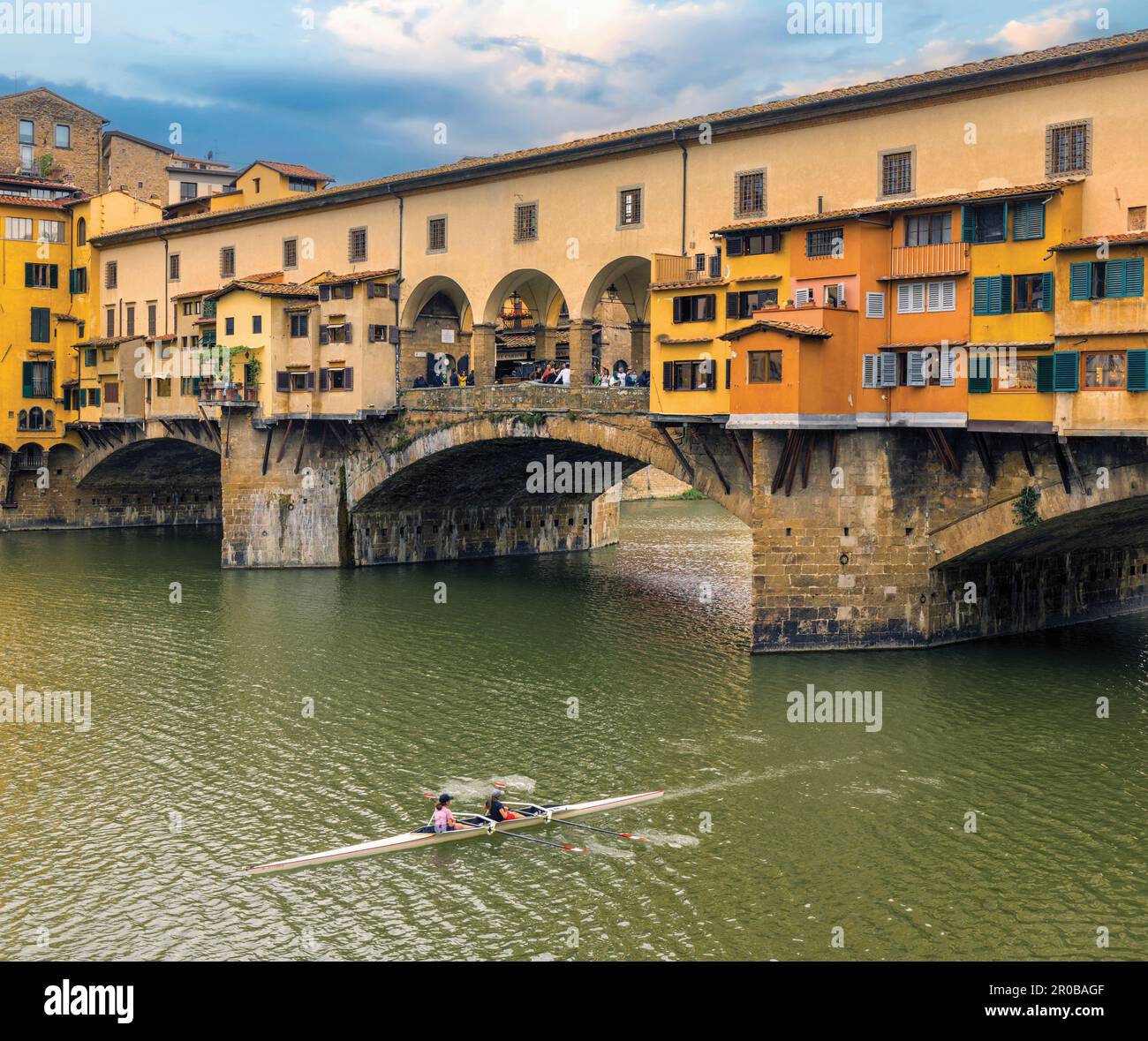 The Ponte Vecchio, the old bridge, on the River Arno and double scullers.  Florence, Tuscany, Italy.  The historic centre of Florence is a UNESCO Worl Stock Photo