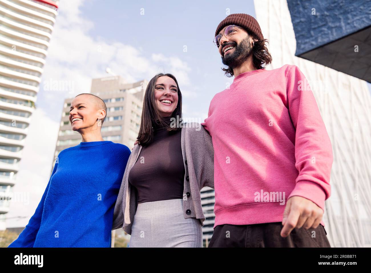 three friends laughing and hugging during a stroll Stock Photo - Alamy