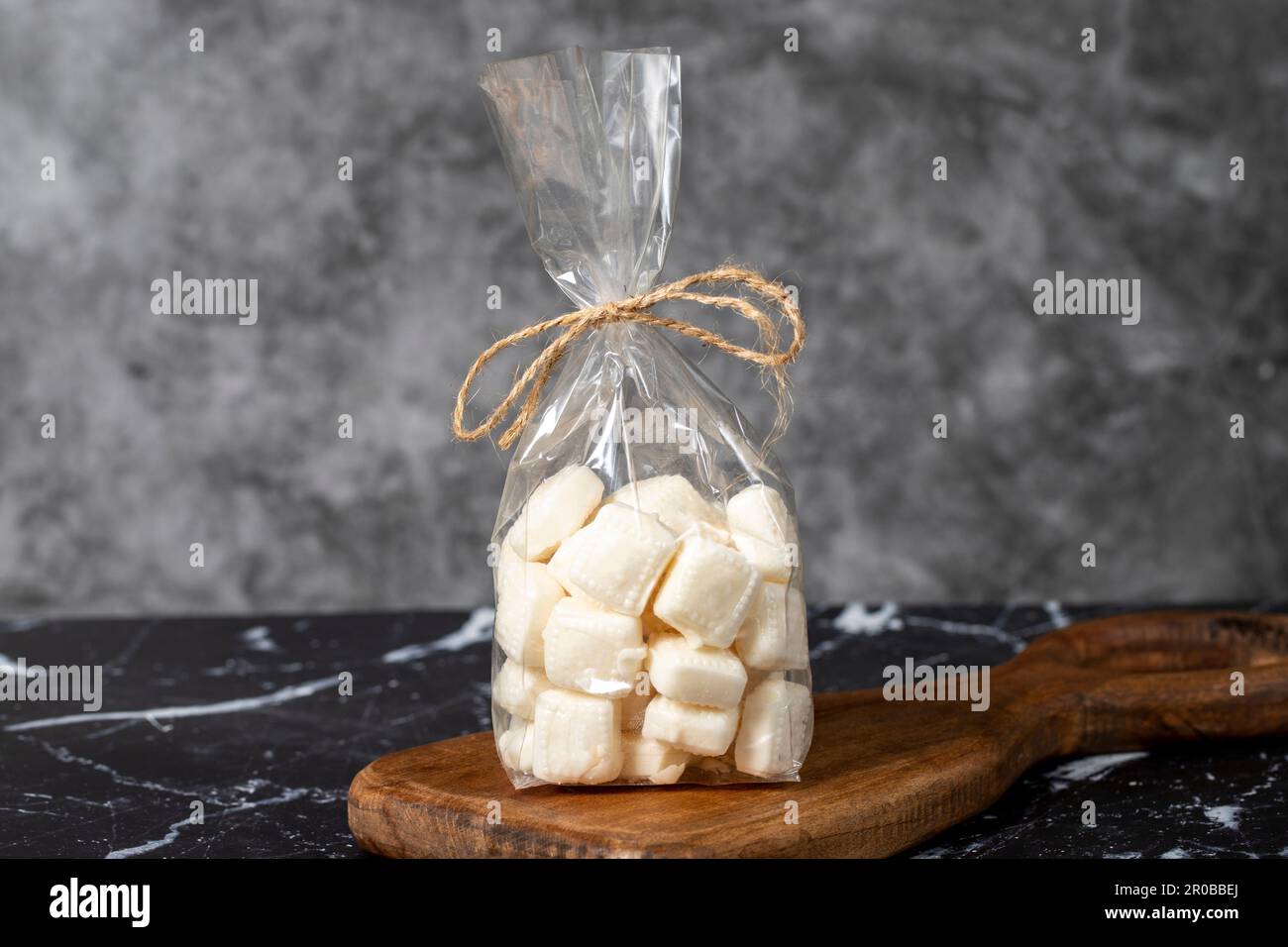 Milk candy. Packed hard milk flavored candy on a dark background. local name mevlana sekeri Stock Photo