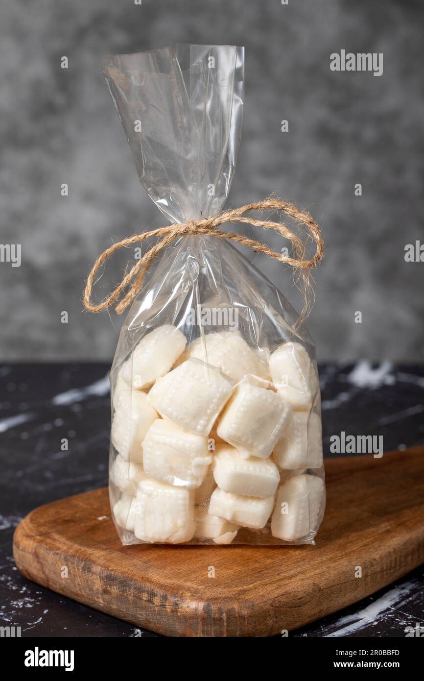 Milk candy. Packed hard milk flavored candy on a dark background. local name mevlana sekeri Stock Photo